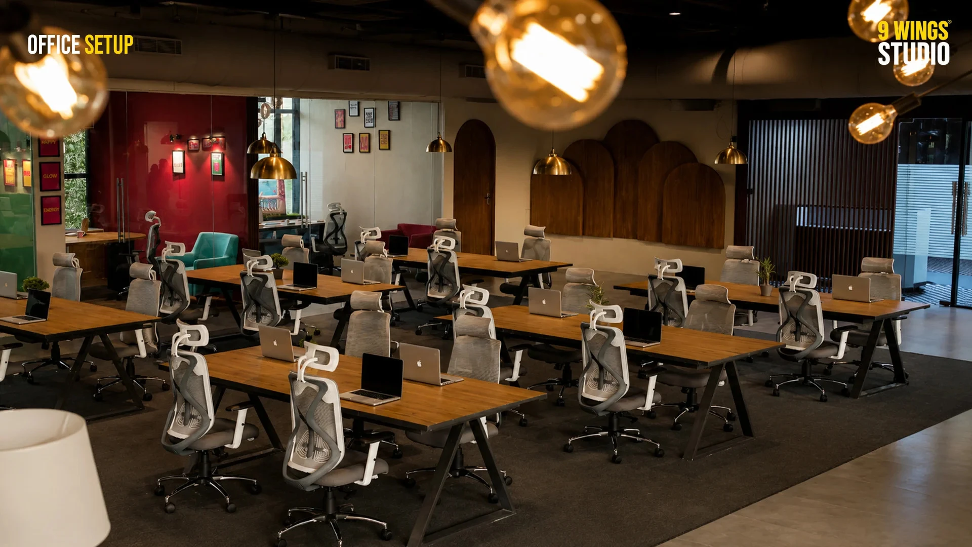 Modern office setup with multiple wooden desks, ergonomic chairs, laptops, pendant lights, and stylish interior decor.
